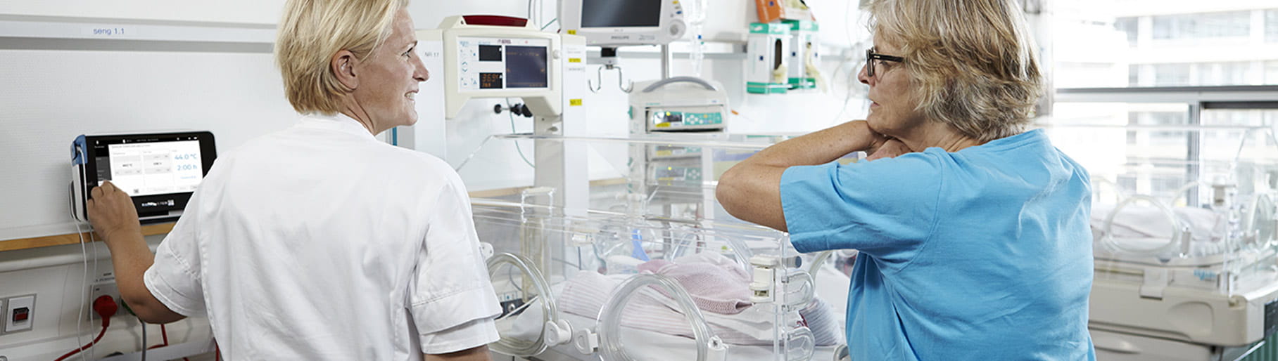 Kórházi helyzet - két ápoló az újszülött intenzív osztályon, a Radiometer transcutan monitorát használva